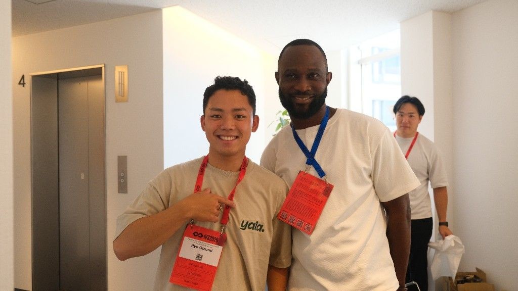 Babatunde with a partner in a Yala shirt at IVS2026